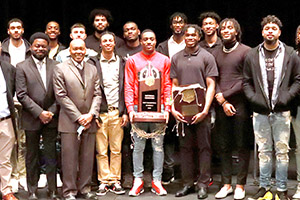 A featured photo of the Men’s Basketball Team presenting its accolades to Chairman Terry R. Wells