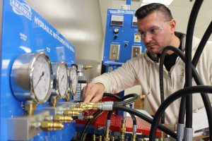 Former student adjusts a hydraulic instrumentation module.