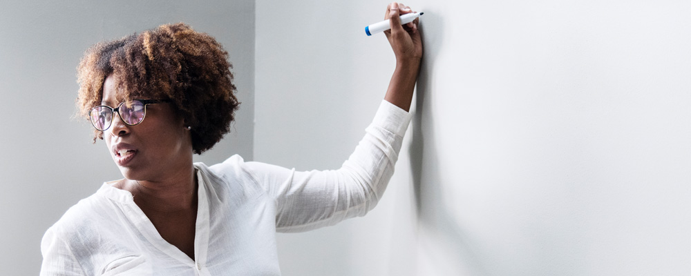 A photo of an instructor writing on the white board.